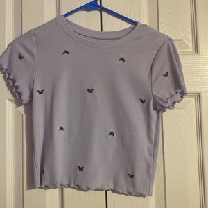 This is a cute purple crop top with black butterflies on it. It’s a size medium.